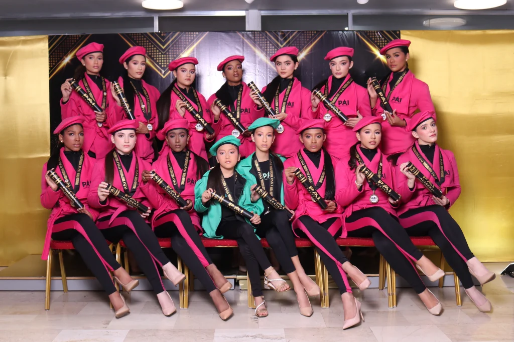 Graduación de la Promo Magenta en academia de modelaje en Caracas con modelos posando en pasarela con diplomas