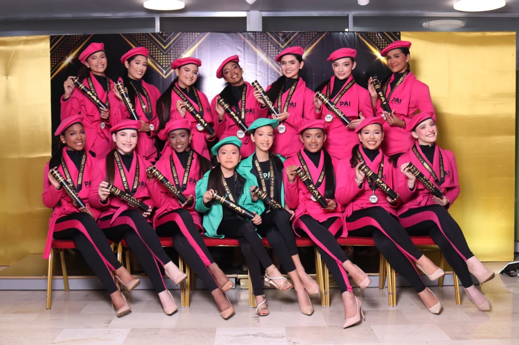 Graduación de la Promo Magenta en academia de modelaje en Caracas con modelos posando en pasarela con diplomas